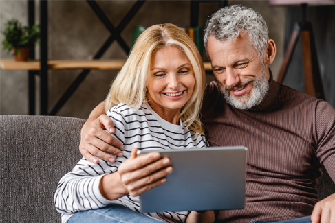 A man and a woman looking at a tablet.